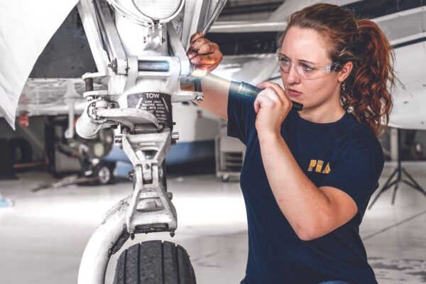 A PIA student inspecting landing gear
