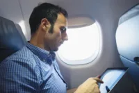 Pensive business man using a digital tablet on the plane